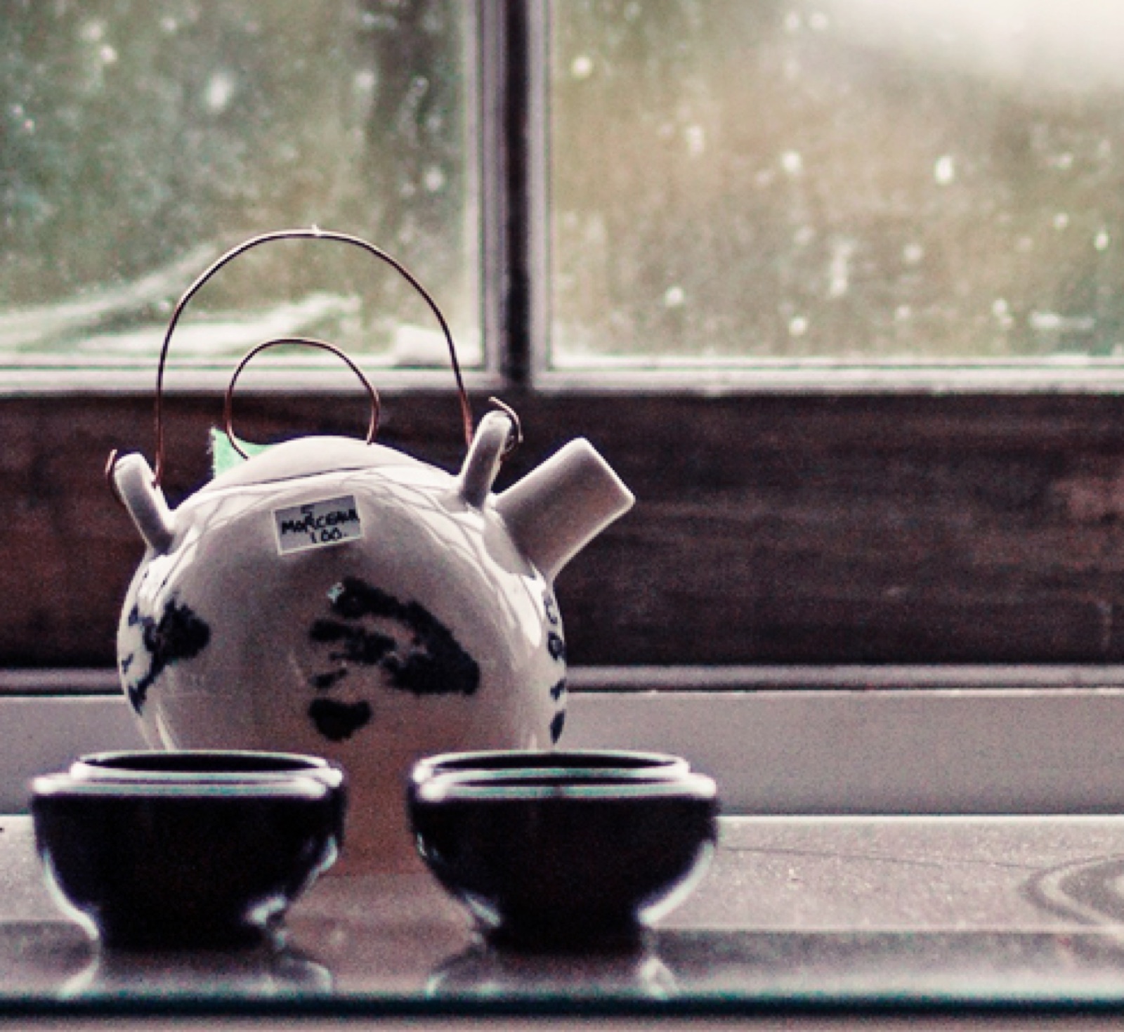 Teapot and two cups on a windowsill
